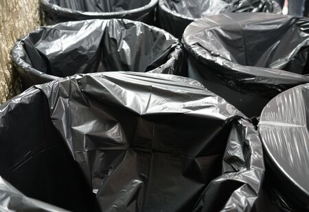 close up on black trash bags in trash binの写真素材
