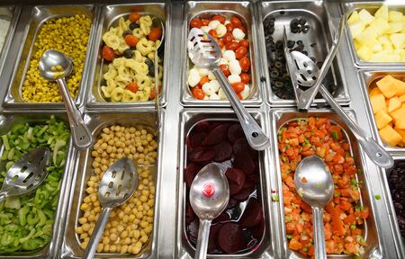 variety of colorful fresh vegetable salad in container in restaurant