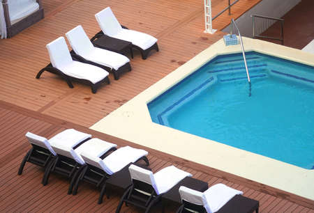 high angle view of beach chairs at the side of swimming poolの写真素材
