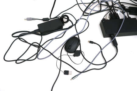 messy electrical wires of electronics equipments on white backgroundの写真素材