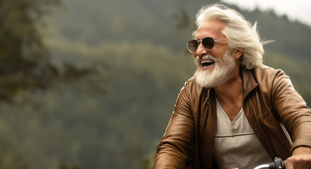 Portrait of senior man in sunglasses riding a motorbike in the mountainsの素材