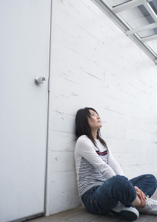 Teenage girl leaning against wallの写真素材