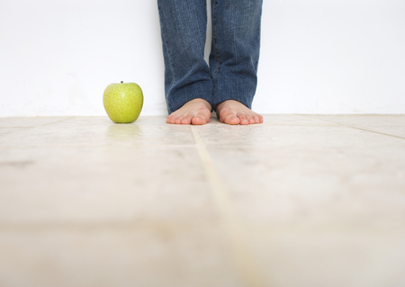 Woman's barefoot and green appleの写真素材