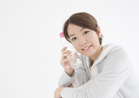 Young woman holding bottle of mineral waterの写真素材
