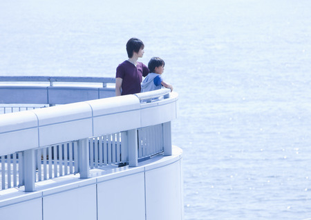 Father and son looking at the seaの写真素材