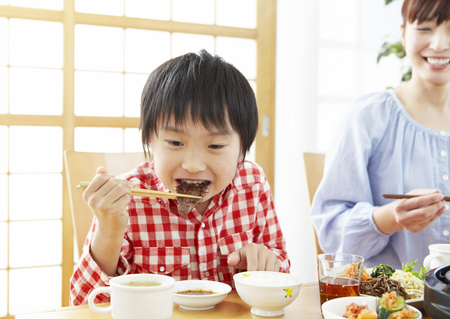Mother and son eating Japanese barbequeの写真素材