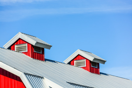 Top roof of new red barn on blue sky backgroundの写真素材