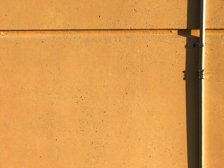 Painted concrete wall with metal conduit on sideの写真素材