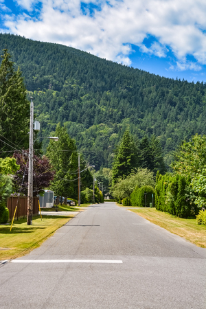 Asphalt road in rural town leading toward a mountainの写真素材