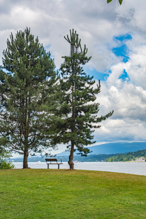 Relaxing place with a bench on a shore of Pacific ocean bayの写真素材