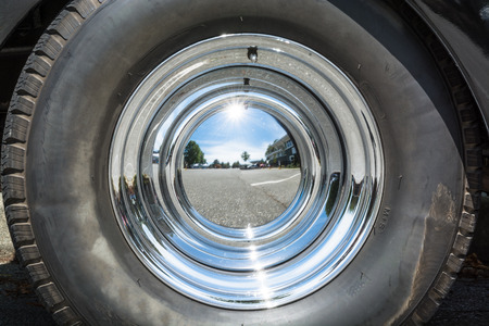 Black tire and chrome mirror cover on the wheel of vintage carの写真素材