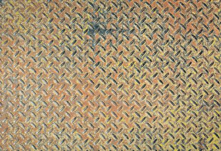 Checkered metal plate painted with different colors. Grundy metal texture background