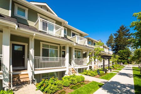 Brand new townhouses with concrete pavement in front. Front side of townhouses on sunny day in...
