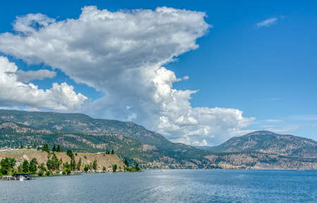Okanagan lake and mountains overview on cloudy sky backgroundの写真素材