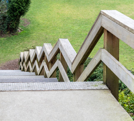 Zig-zag railings of wooden stairway on green grass backgroundの写真素材