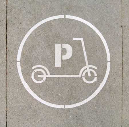 Electric scooter parking stall sign on concrete pavement surfaceの写真素材