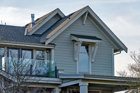 Top of residential house with small patio on overcast sky background