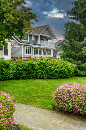 Residential family house with gravel pathway along side on cloudy sky backgroundの写真素材