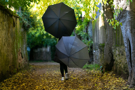 woman with umbrella, walking along the roadの写真素材