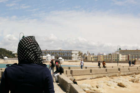 Free woman walking by the sea with her head covered in the area of Cadizの写真素材