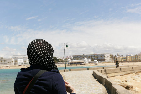 Free woman walking by the sea with her head covered in the area of Cadizの写真素材