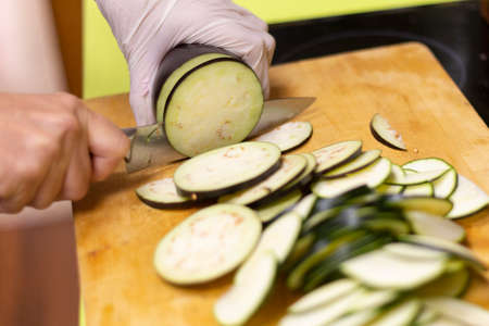 Sliced zucchini cut on top of wooden board with knife