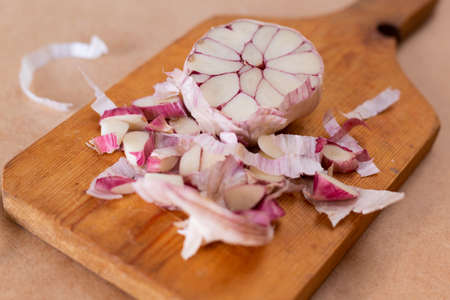 Head of garlic split in half on wooden board