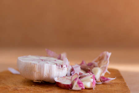 Head of garlic split in half on wooden board