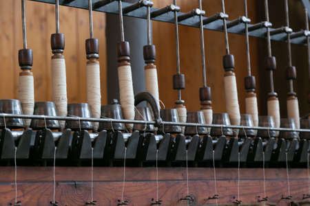 Old loom, spinning machine, rows of white and colored cotton threads