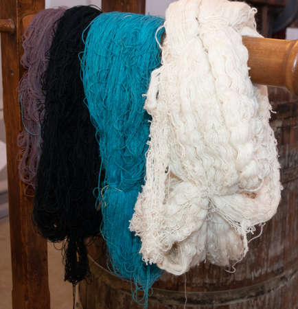 Old loom, spinning machine, rows of white and colored cotton threadsの写真素材