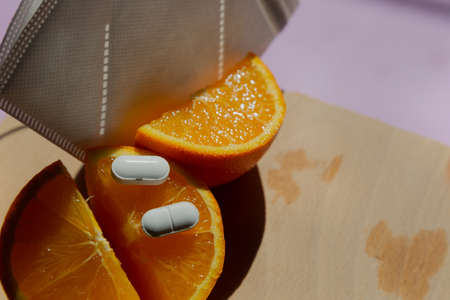 orange vitamin C and pills with mask bottomon wooden board Immunity protection concept, antiviral...