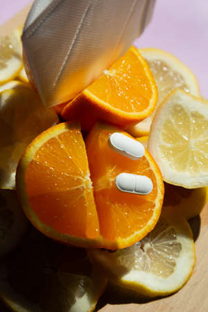 orange vitamin C and pills with mask bottom on wooden board Immunity protection concept, antiviral preventionの写真素材