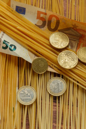 Coins and paper money on pasta, concept of rising prices in agricultureの写真素材