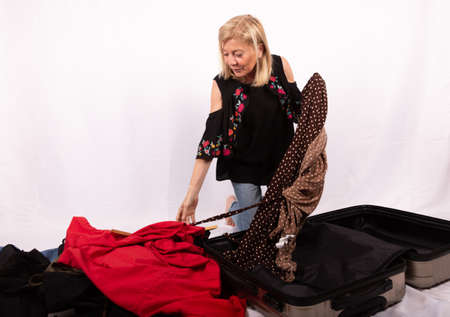 Mature woman happy with her clothes shopping in the salesの写真素材