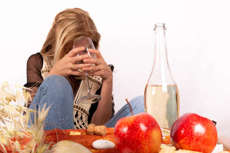 Mature blonde woman, toasting alone with a glass of wine, white backgroundの写真素材