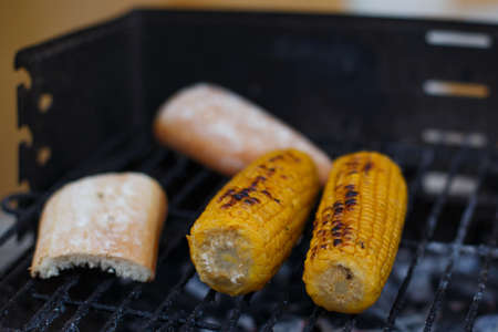 Corn cobs put on the barbecue with bread on a summer holidayの写真素材