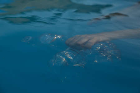 Hands in the water emptying a plastic bottle,maritime