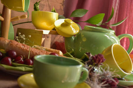 Coffee and tea set with cherries and pastries in green and yellow, product pictureの写真素材