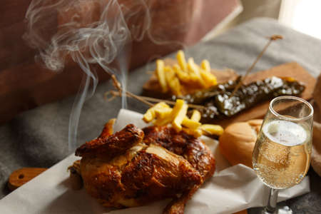 Freshly roasted chicken with potatoes, on a wooden tableの写真素材