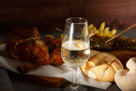 Freshly roasted chicken with potatoes, on a wooden tableの写真素材