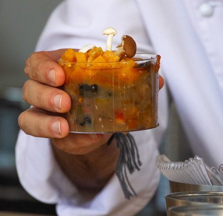 A detailed examination of an individual holding a plate of food, observing its contents closely like ingredients, liquids, and cuisine elements with keywords like fast food and tablewareの写真素材