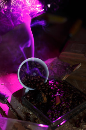 Vibrant Coffee Beans surrounded by Ethereal Smoke illuminated Under a Purple Lightの写真素材