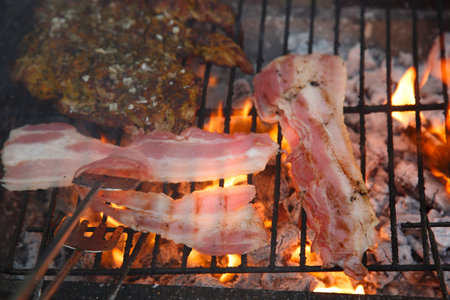 Grilling delicious Bacon and Chicken on a Charcoal Grill for an amazing cookout experienceの写真素材