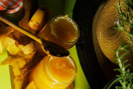 Delicious and Homemade Fruit Jam Presented in Jars with a Spoon Alongside Natural Elementsの写真素材