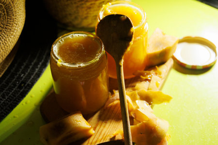 Delicious and Homestyle Natural Honey, Lovingly Filled in Jars Alongside a Wooden Spoon for Servingの写真素材