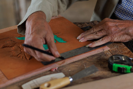 Hands, working like a carpenter, tracing on embossed leather, manually, artisan work.