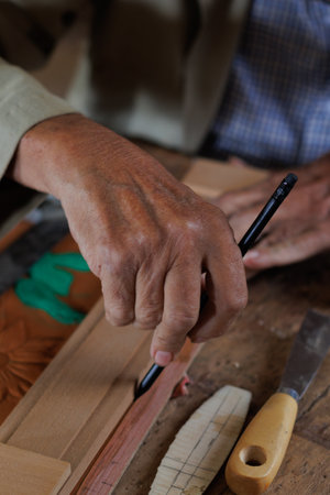 Hands, working like a carpenter, tracing on embossed leather, manually, artisan work.