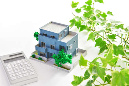Real estate image, miniature house and calculator.の写真素材