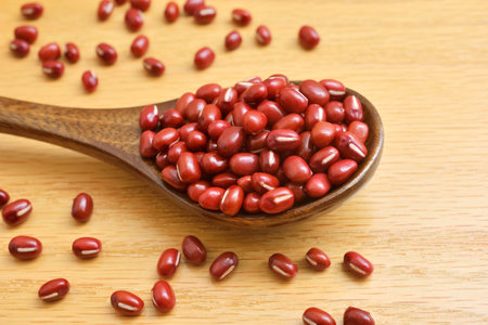 Glossy adzuki beans on a wooden board.
