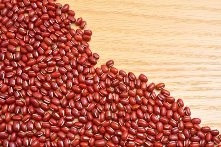 Glossy adzuki beans on a wooden board.